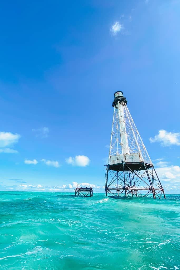 lighthouse sticking out of the turquoise water on a sunny day in islamorada