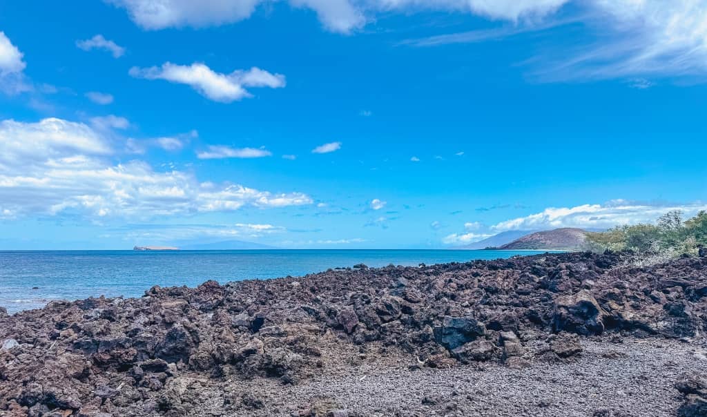 Hawaii coastline with rugged volcanic rock on the coastline overlooking the ocean on a sunny day