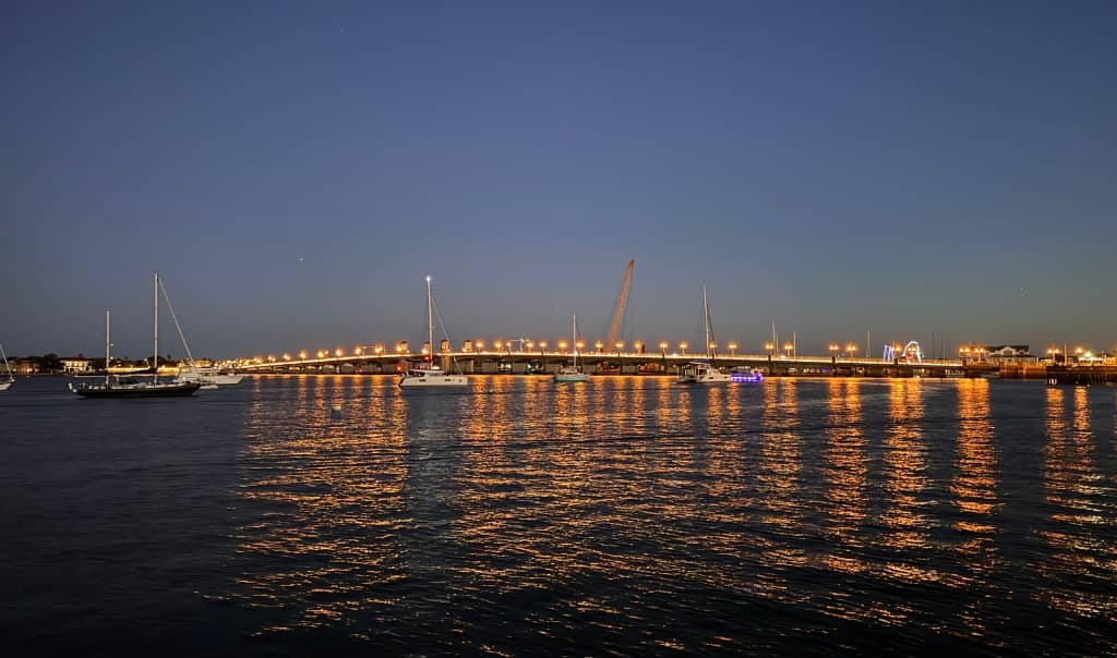 the bridge of lions lit up with boats on the water