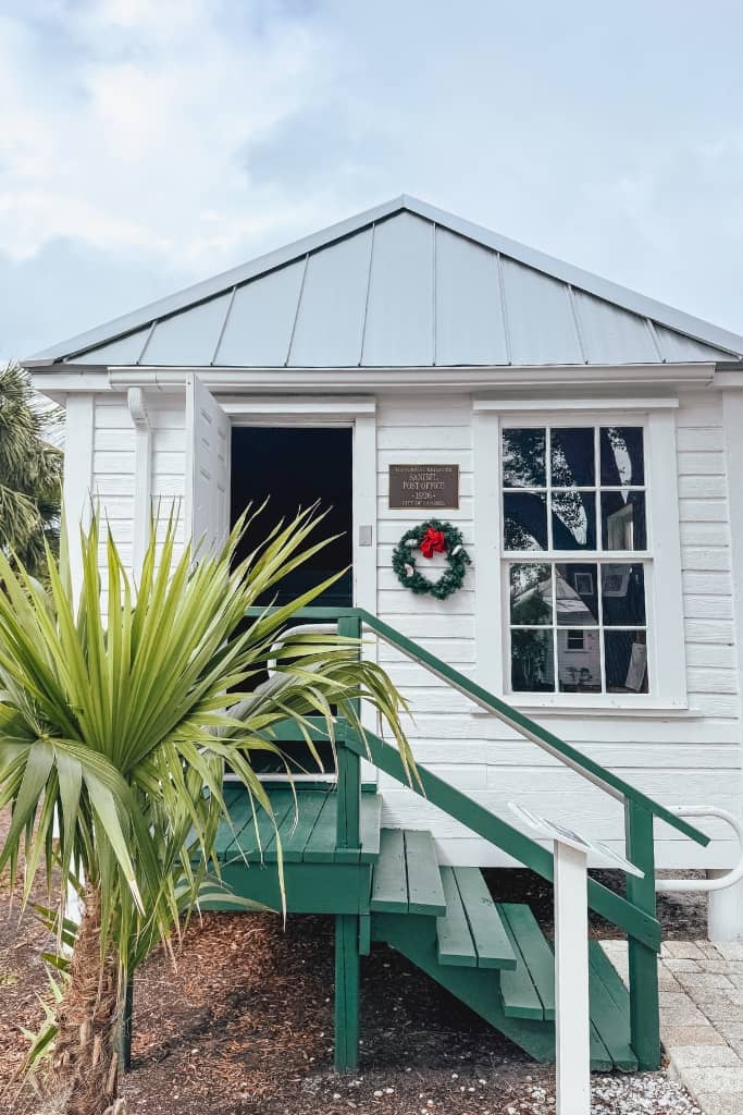 historic white building with a tropical tree in front of it at history museum and village in sanibel island