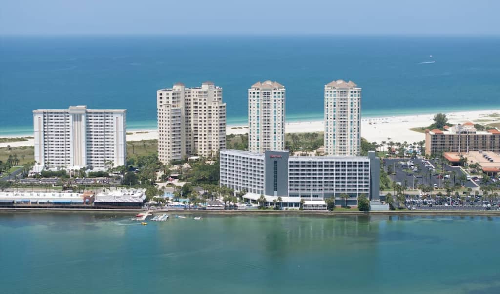 aerial view of Clearwater Beach Marriott Resort on Sand Key sitting along the bay with other condos behind it lining sand key beach 
