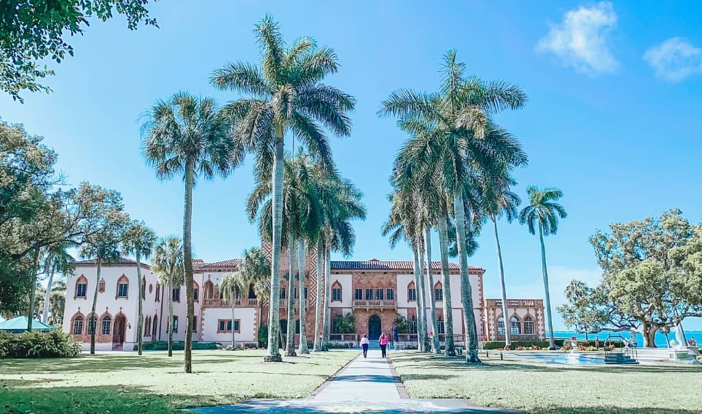 Ca' d'Zan Mansion at the ringling museum surrounded by a palm tree walkway