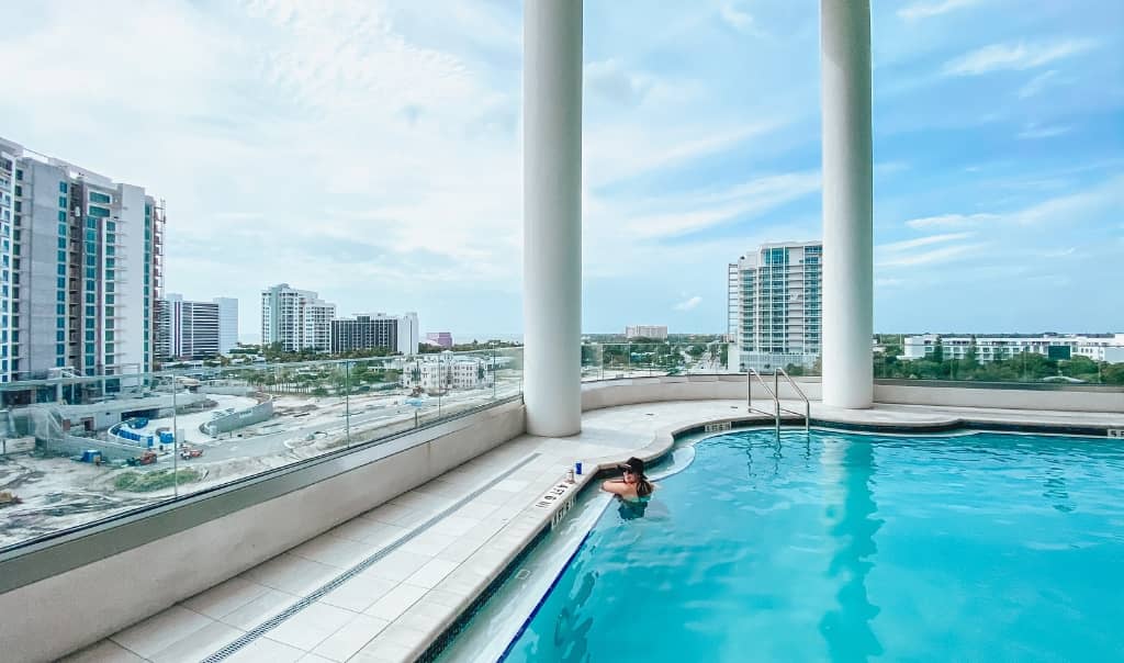 young girl in a rooftop pool in sarasota overlooking downtown sarasota and the bay