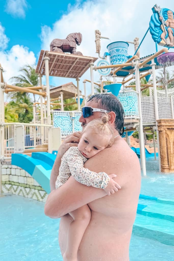 dad holding one year old at a splash park for young kids at atlantis bahamas