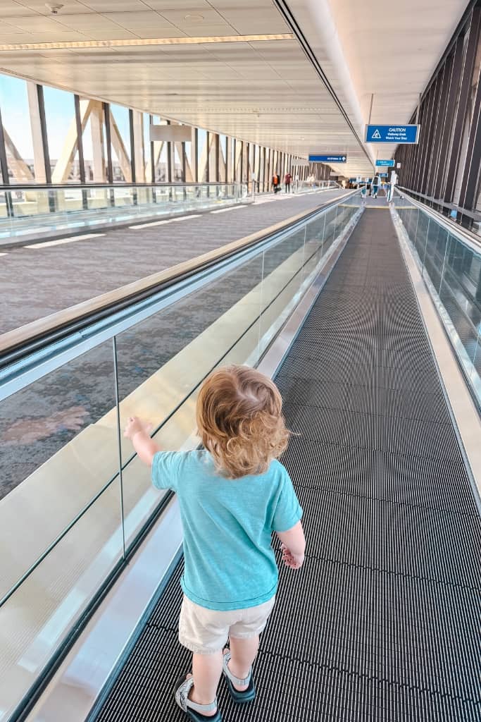 toddler boy walking the escalator in the airport 