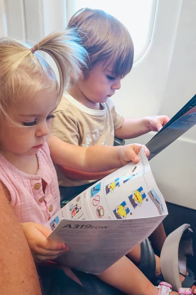 toddler boy and toddler girl looking at airplane handouts 
