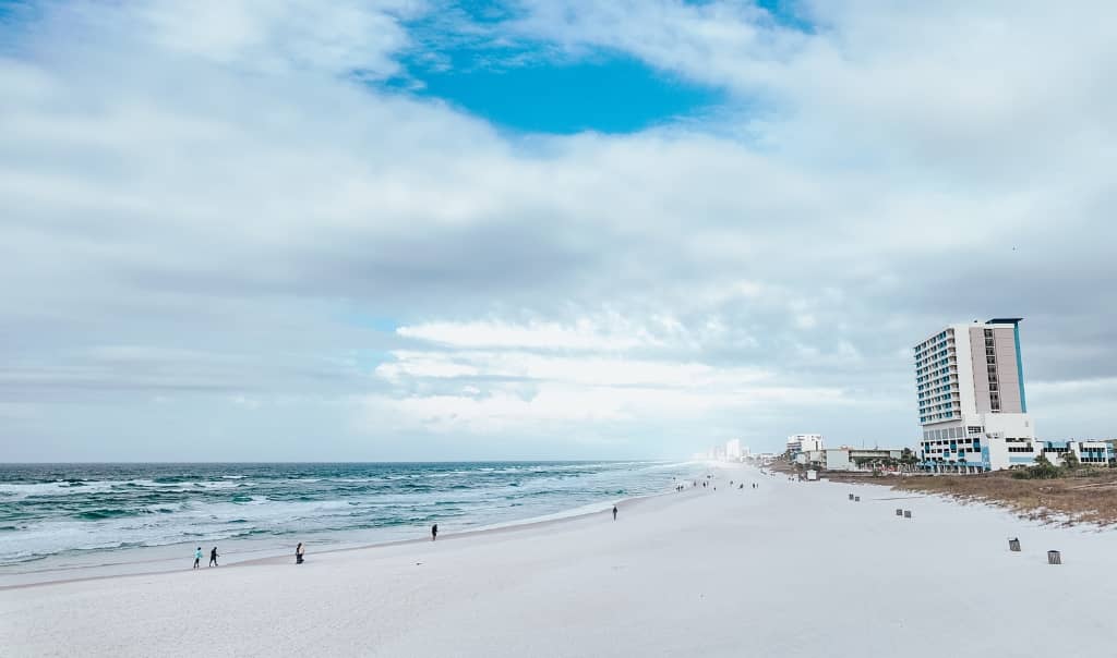 beach on a sunny day with a wide sandy area lined with 2 high rise buildings